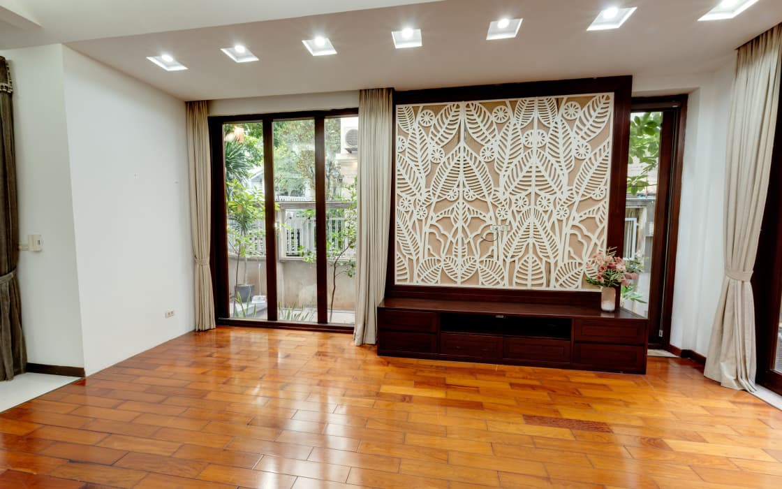 Phòng khách sàn gỗ, vách CNC hoạ tiết lá